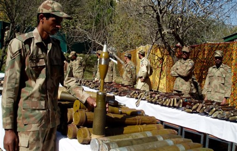 Pakistan army soldiers stand near confiscated arms and ammunition during operations against militants in Kalaya in Pakistan's tribal area of Orakzai near the Afghanistan border on Tuesday, Oct. 26, 2010. The Pakistani military's offensive against the Taliban in this small but strategic tribal region is succeeding, commanders say. Seven months after the offensive's launch, 90 percent of Orakzai is cleared, civilians are slowly returning, and schools and homes are being rebuilt. (AP Photo/Nabeel Yousaf)
